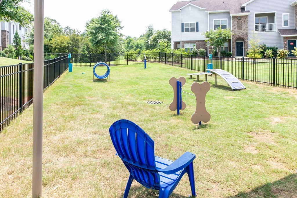 a park with a playground and a chair in the grass at Century HomePlace, Prattville, AL 36066