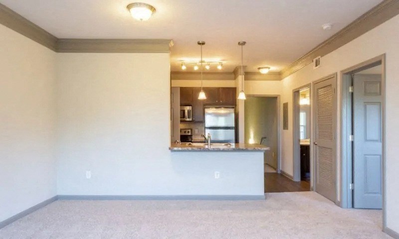 an empty living room with a kitchen and a at Century HomePlace, Prattville