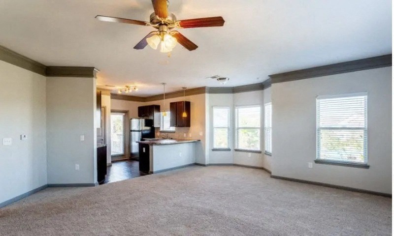 an empty living room with a ceiling fan and a kitchen at Century HomePlace, Prattville Alabama