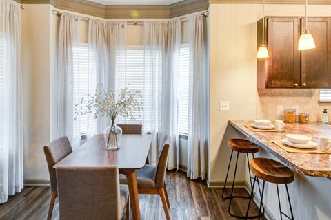 a dining room and kitchen with a table and chairs