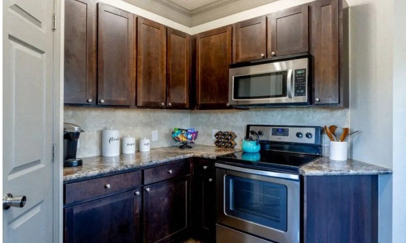 a kitchen with stainless steel appliances and wooden cabinets at Century HomePlace, Alabama, 36066