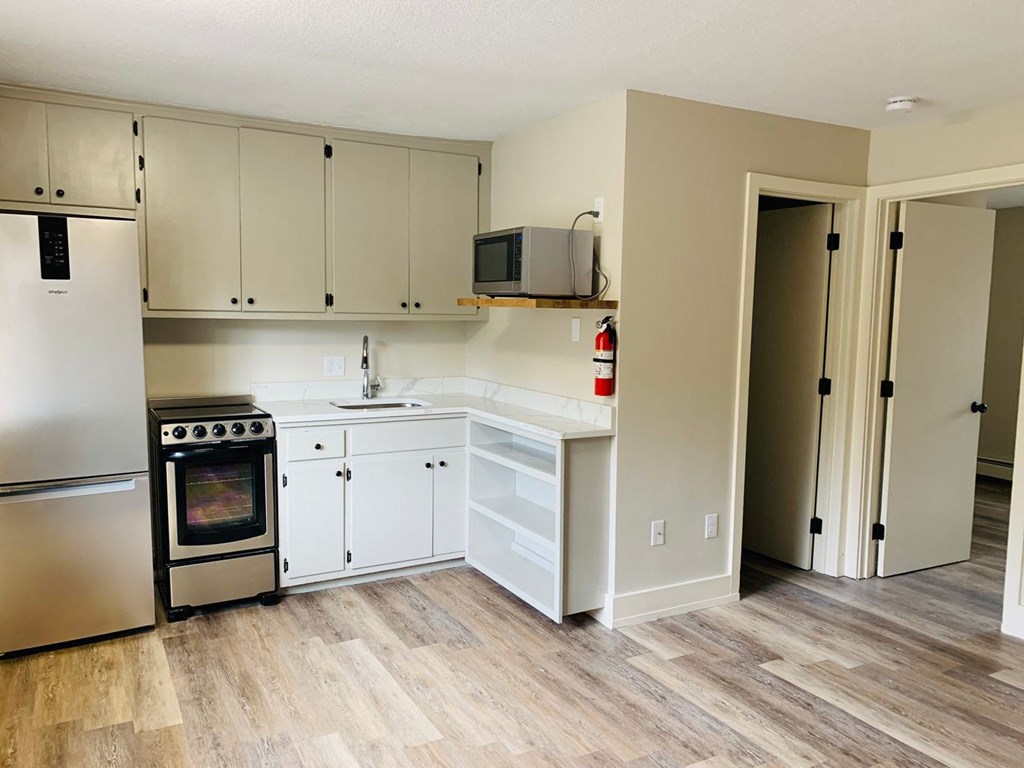 a kitchen with white cabinets and a wood floor at Briarcliff at Quechee, Quechee