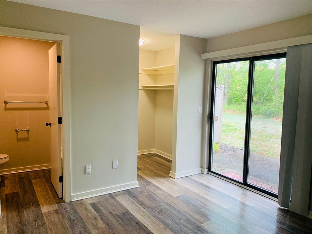 a living room with a sliding glass door and a closet  at Briarcliff at Quechee Apartments, Vermont