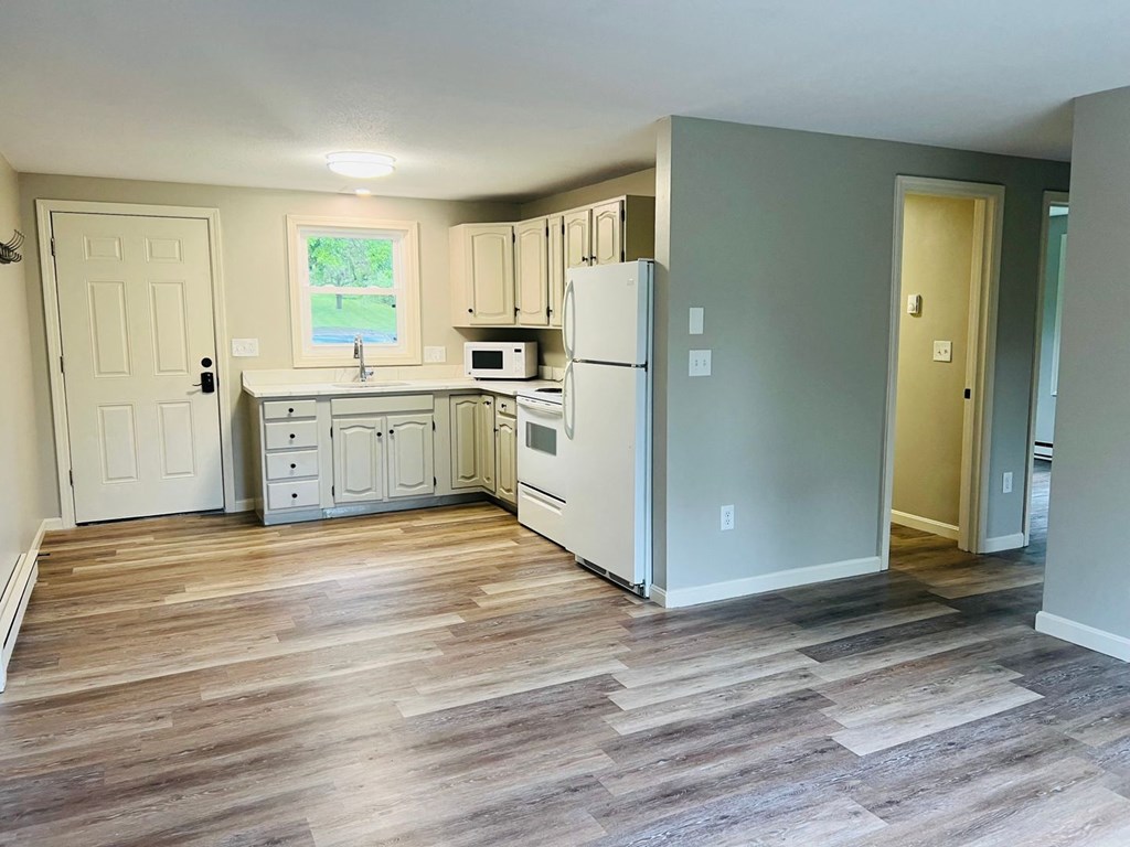 a renovated kitchen with white cabinets and a wood floor at Briarcliff at Quechee, Vermont