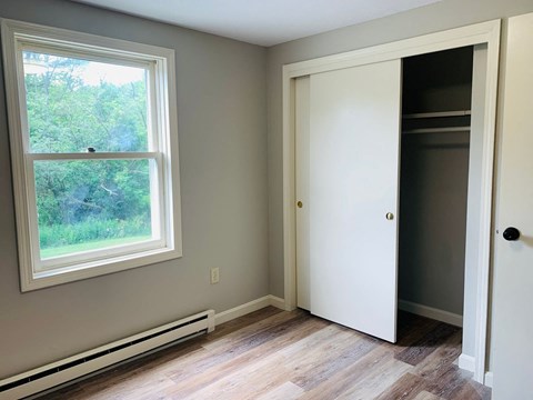 Bedroom with sliding closet door and large window at Briarcliff at Quechee Apartments, Vermont, 5059