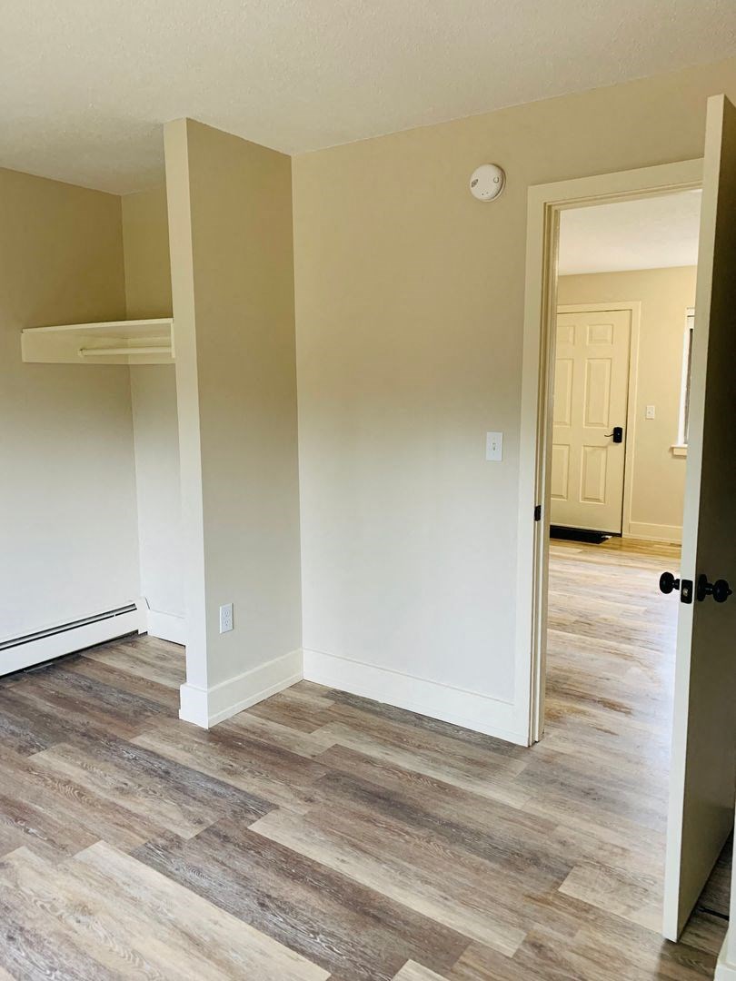 a living room with wood floors and a white door at Briarcliff at Quechee, Quechee, 05059