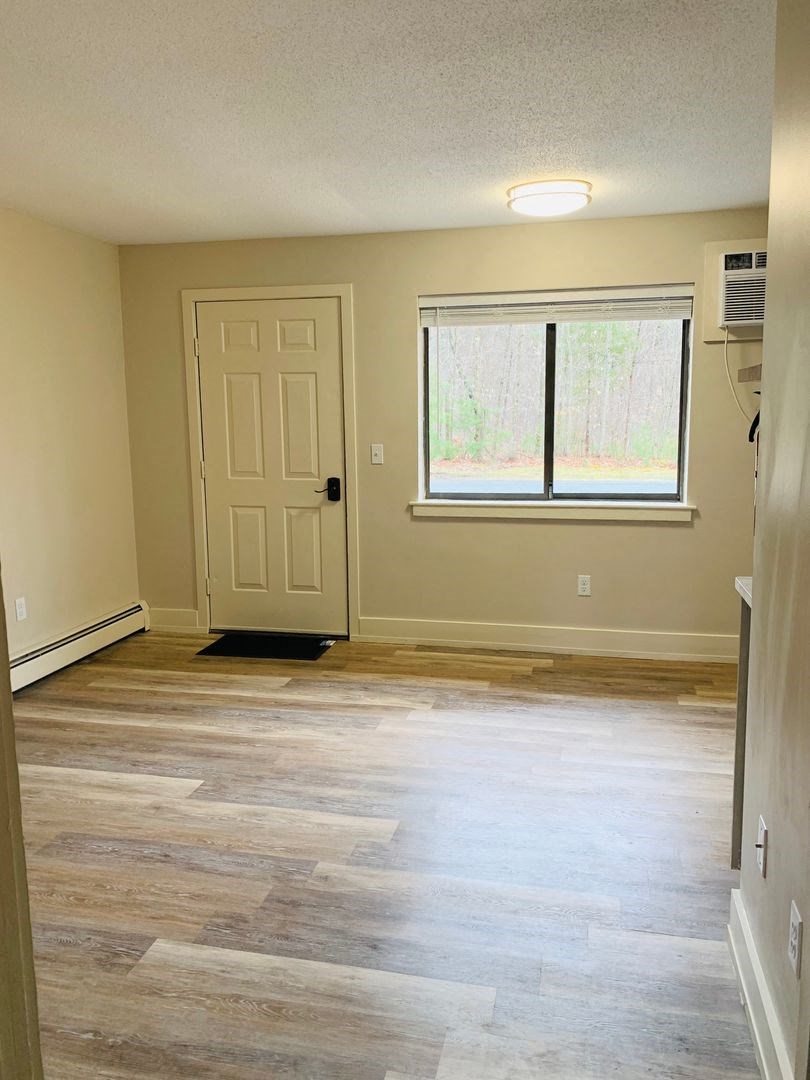 an empty living room with wood floors and a window at Briarcliff at Quechee, Vermont, 05059