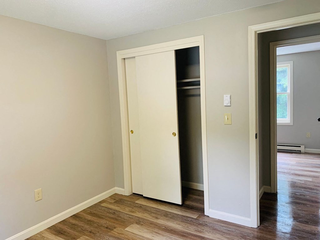 a bedroom with a door open to a closet and a hard wood floor at Briarcliff at Quechee, Quechee