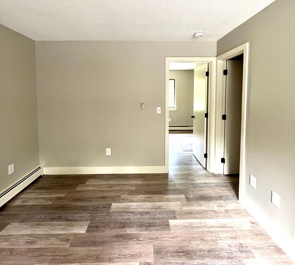 a renovated living room with wood floors and a hallway to a bedroom at Briarcliff at Quechee, Quechee, VT