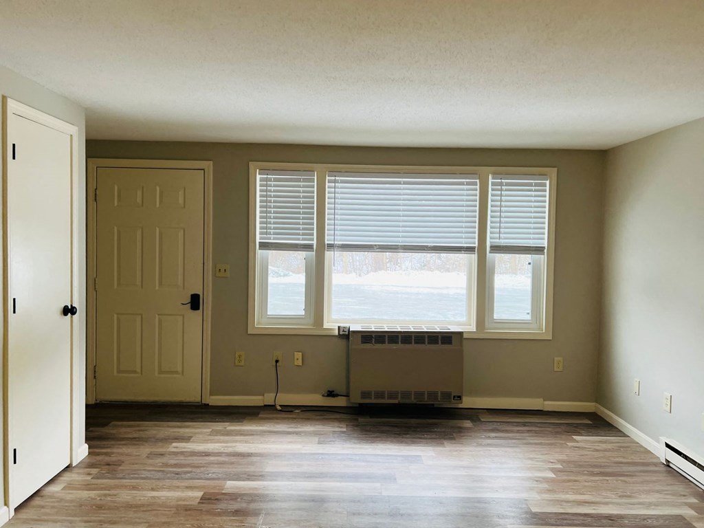 an empty living room with a large window and a door at Briarcliff at Quechee, Vermont, 05059
