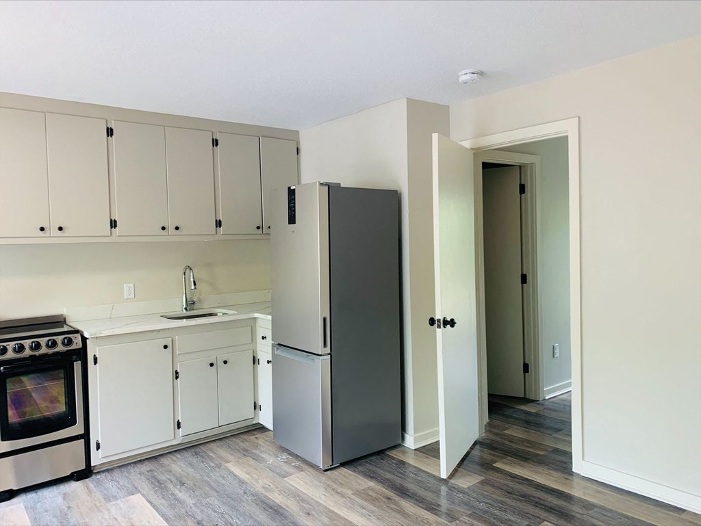 a kitchen with white cabinets and a stainless steel refrigerator at Briarcliff at Quechee, Quechee