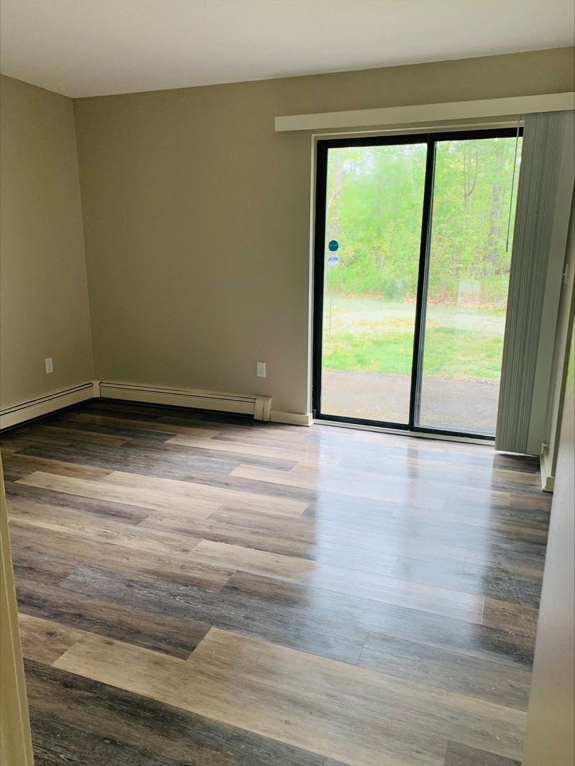 a living room with wood floors and a sliding glass door at Briarcliff at Quechee, Quechee Vermont