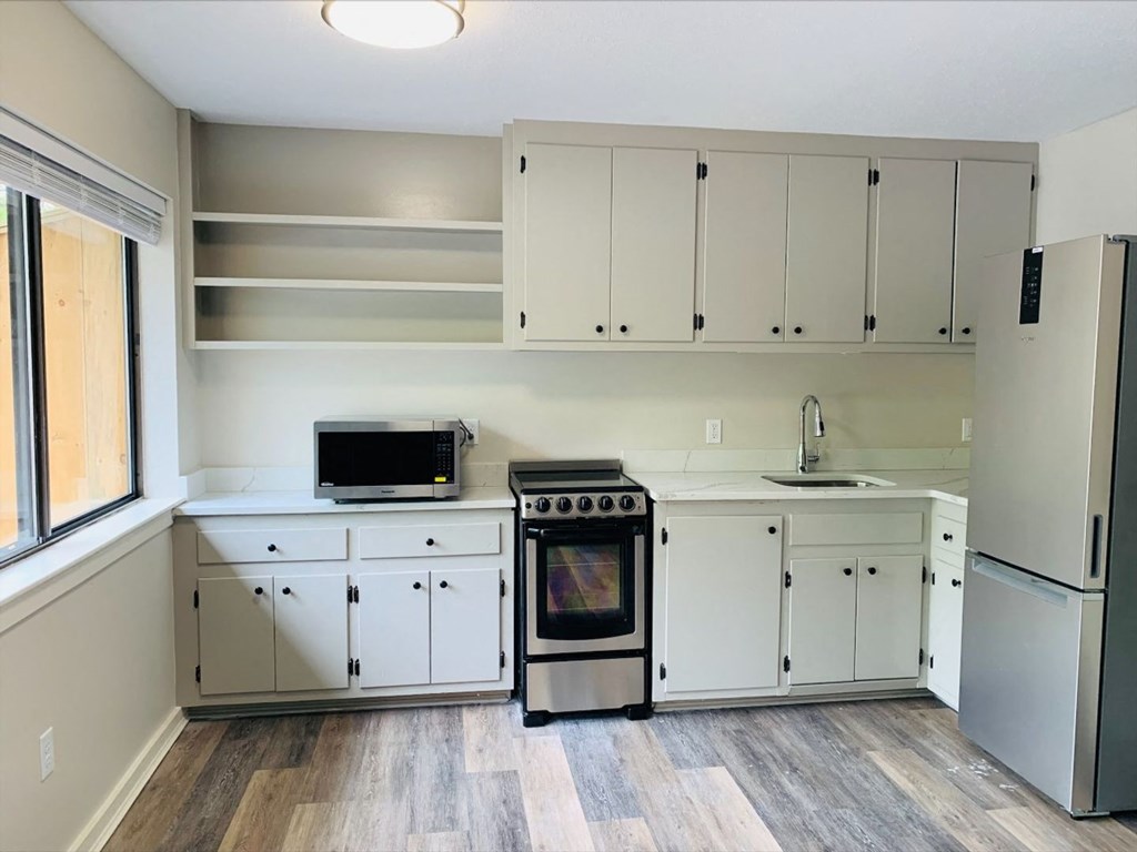 a kitchen with white cabinets and a stove and a refrigerator at Briarcliff at Quechee, Quechee Vermont