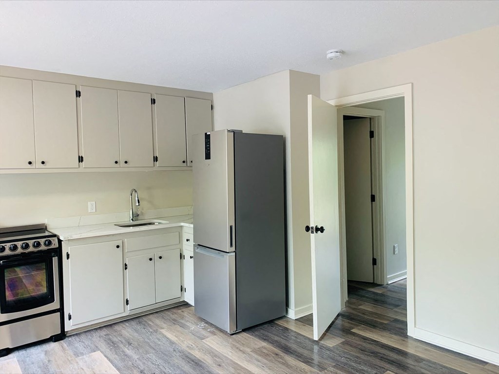 a kitchen with white cabinets and a stainless steel refrigerator at Briarcliff at Quechee, Vermont