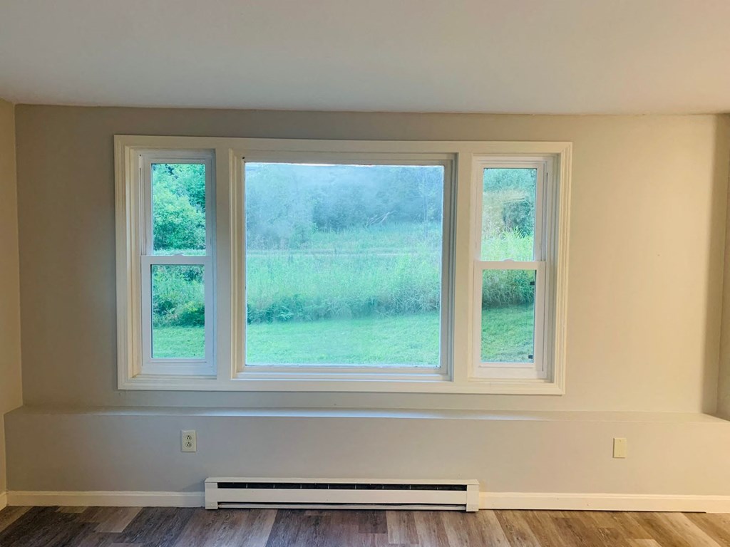 a room with three windows and a wood floor at Briarcliff at Quechee, Quechee, VT