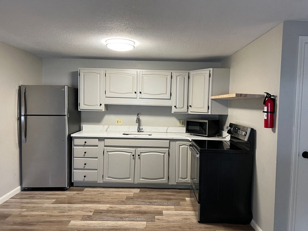 a kitchen with white cabinets and a stainless steel refrigerator at Briarcliff at Quechee, Vermont