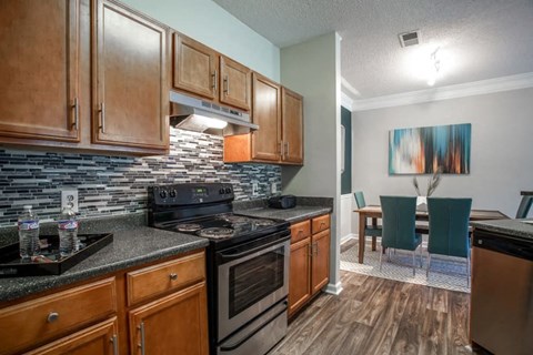 A kitchen with wooden cabinets and a black stove top oven.
