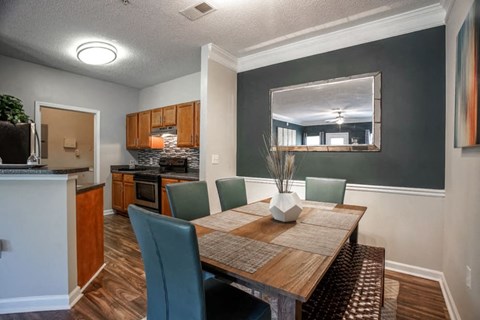 a dining room table with a kitchen in the background