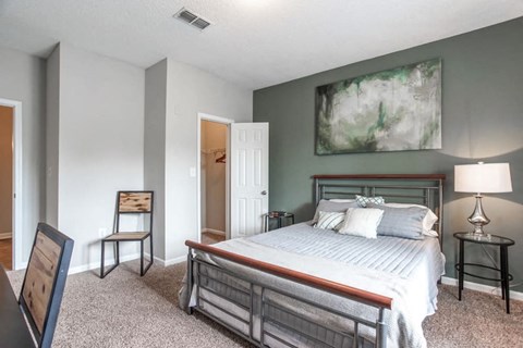 a bedroom with a bed and a painting on the wall