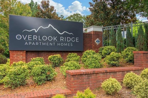 an overhead ridge apartment homes sign in front of a brick wall