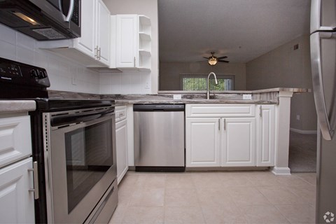a kitchen with white cabinets and stainless steel appliances