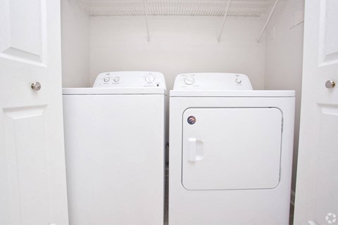 a white washer and dryer in a white laundry room