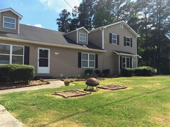 a house with a yard and a garden in front of it