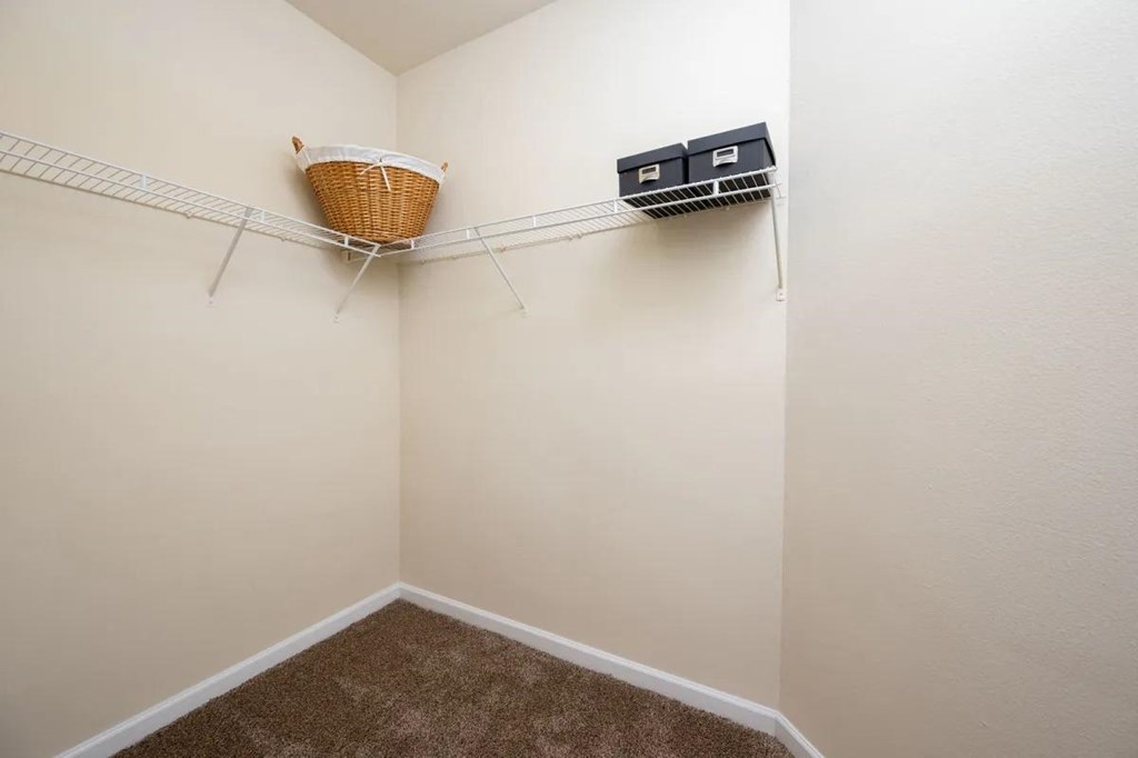 a closet with a basket hanging on the wall