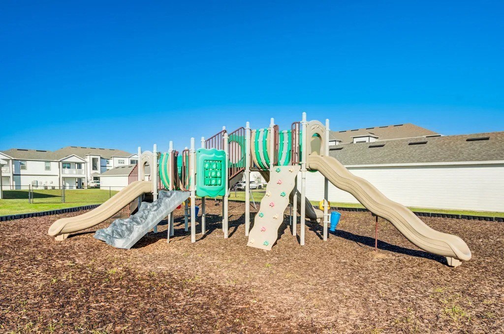 A playground with a green slide and a brown slide.at Century Ariva, Lakeland, 33812  