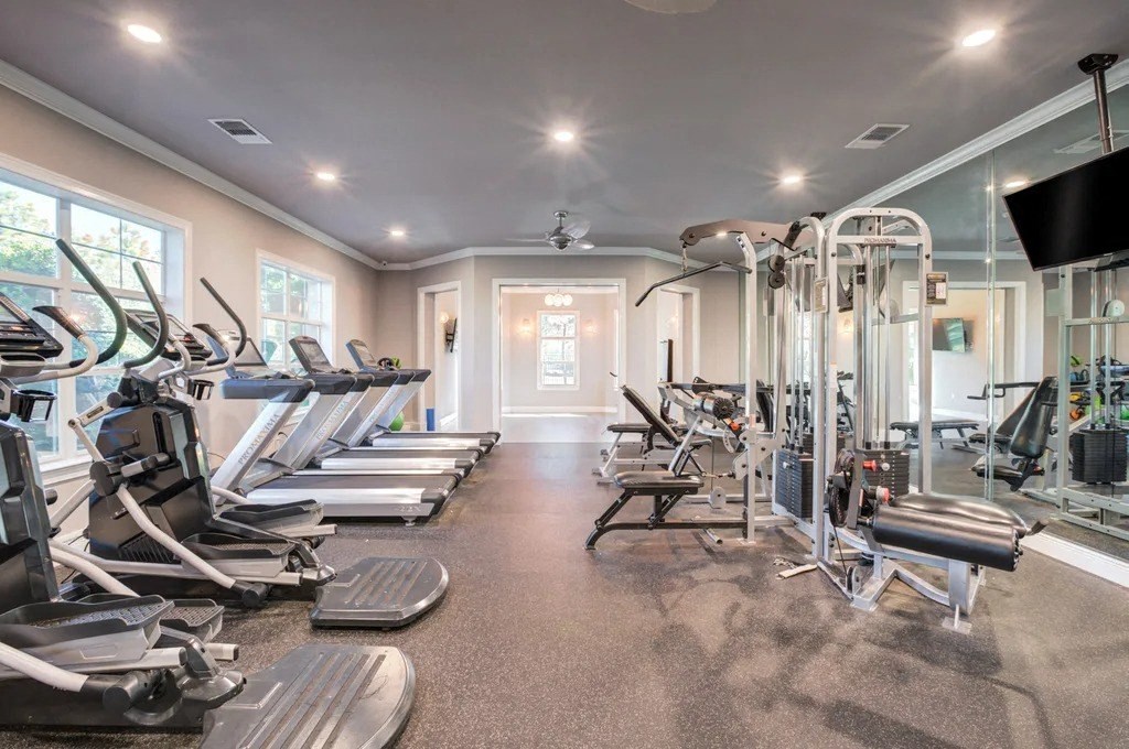 A well-lit gym with treadmills, elliptical machines, and other exercise equipment.at Century Ariva, Lakeland, 33812  