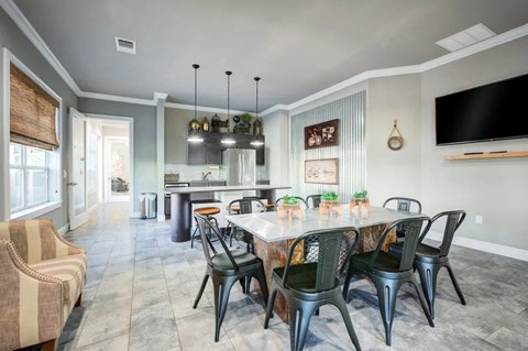 A dining room with a table set for six and a television mounted on the wall.at Century Ariva, Florida