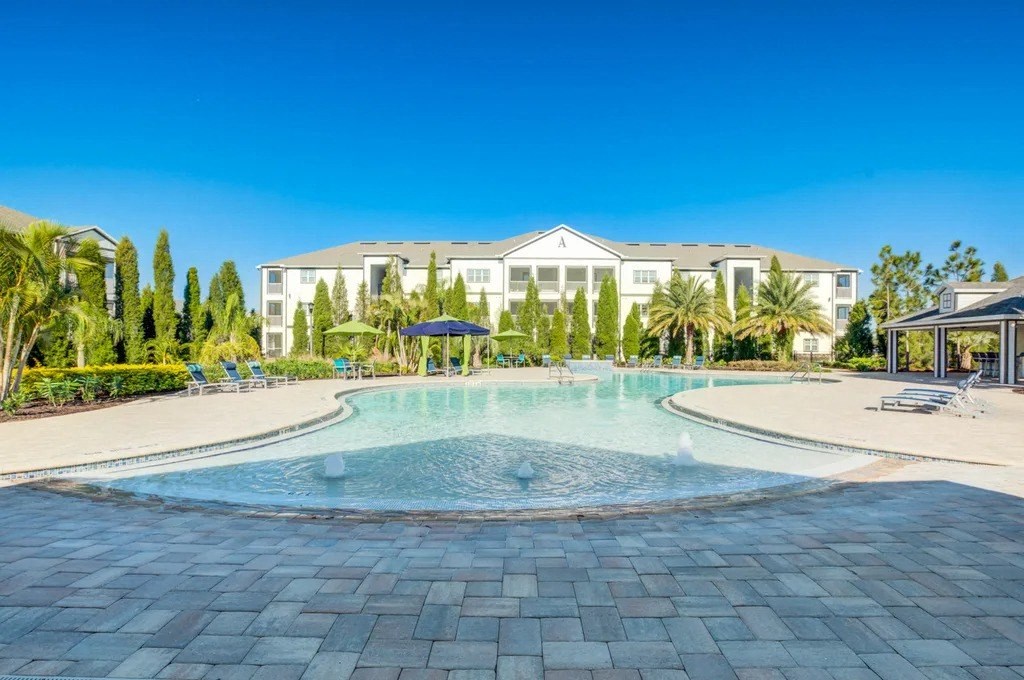 A large white building with a pool in front.at Century Ariva, Lakeland, FL 33812  