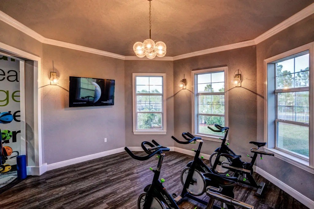 A room with a television, a window, and exercise bikes.at Century Ariva, Lakeland, FL 33812  