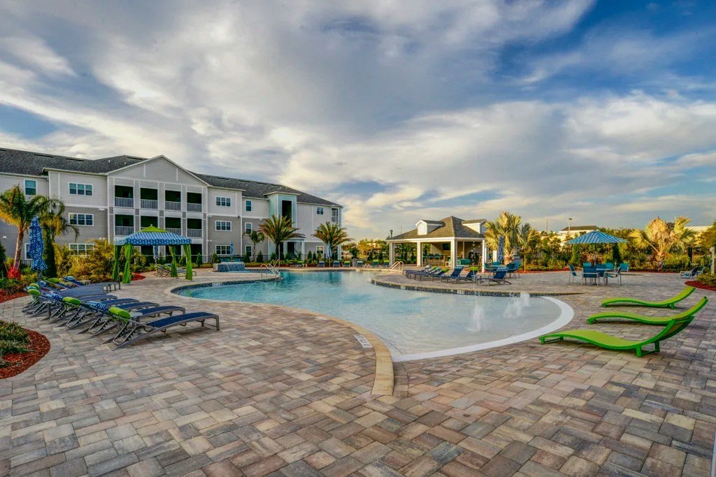 A large outdoor swimming pool surrounded by a brick patio and lounge chairs.at Century Ariva, Lakeland, 33812  