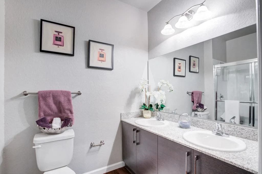 A bathroom with a toilet, sink, and towel rack.at Century Ariva, Lakeland, FL 33812  
