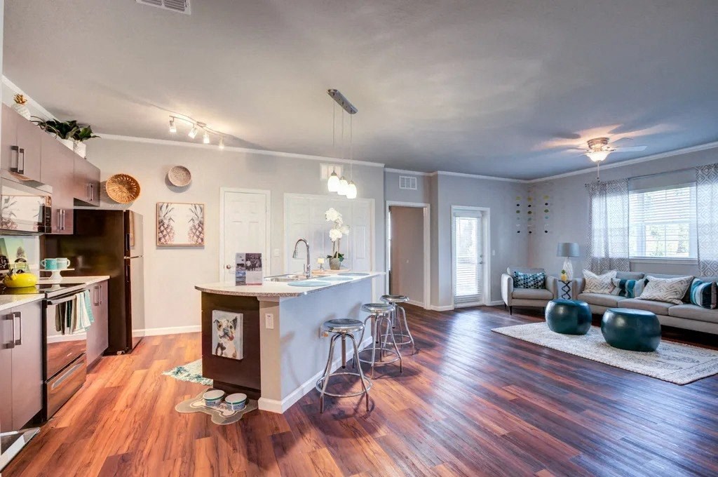 A kitchen with a white island and a dining area with a white table and chairs.at Century Ariva, Lakeland, Florida  