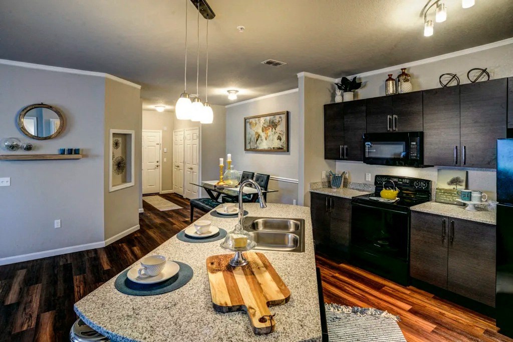 A kitchen with a granite countertop and a wooden cutting board at Century Ariva, Florida  .