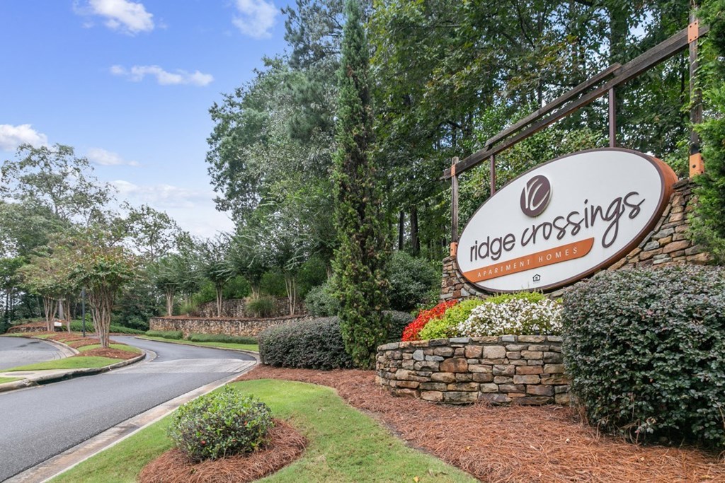 A sign for Ridge Crossings residential community is displayed in front of a landscaped area at Ridge Crossings Apartments, Hoover, AL