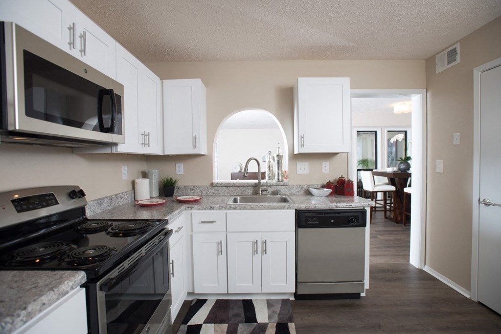 A kitchen with white cabinets and a black and white checkered floor at Ridge Crossings Apartments, Hoover, Alabama