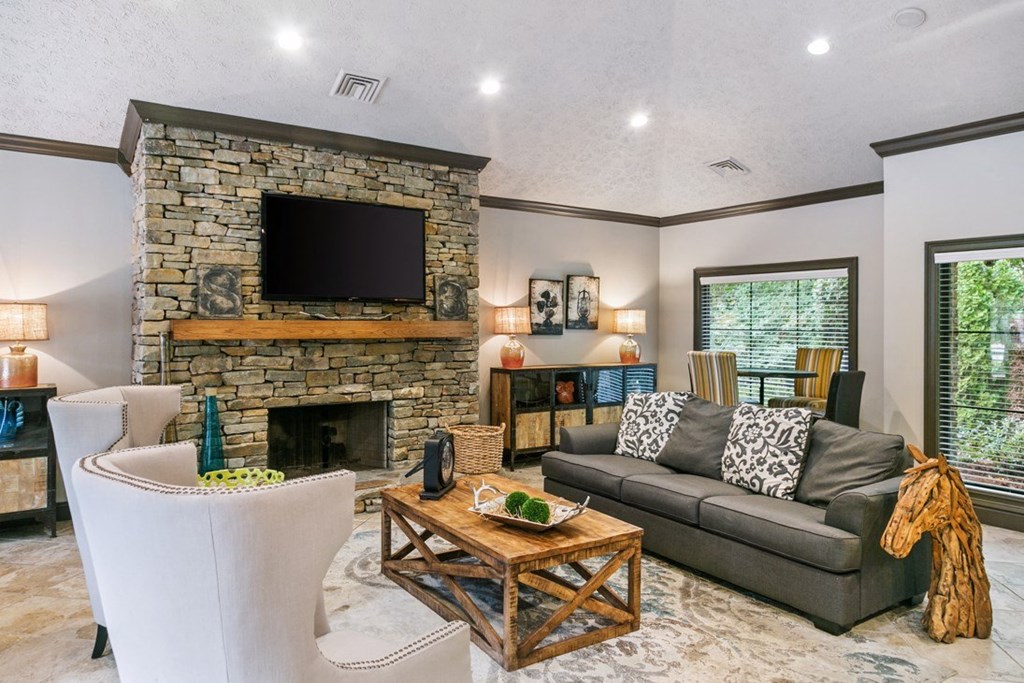 A living room with a stone fireplace and a grey couch at Ridge Crossings Apartments, Hoover, 35244
