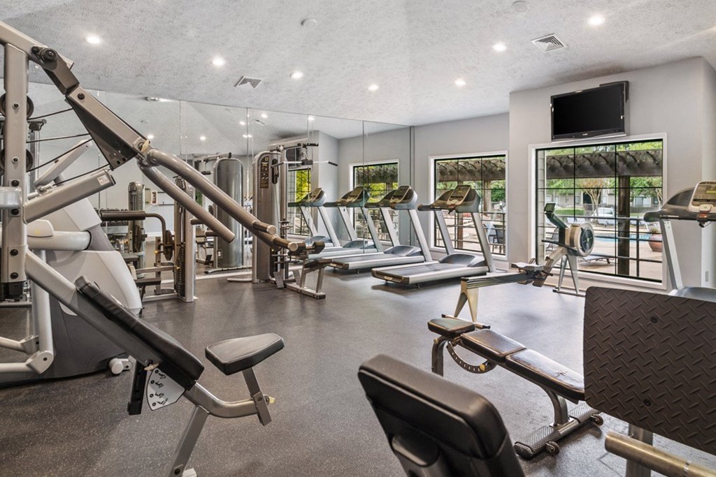 A gym with a variety of equipment including treadmills, weights, and exercise machines at Ridge Crossings Apartments, Hoover, 35244