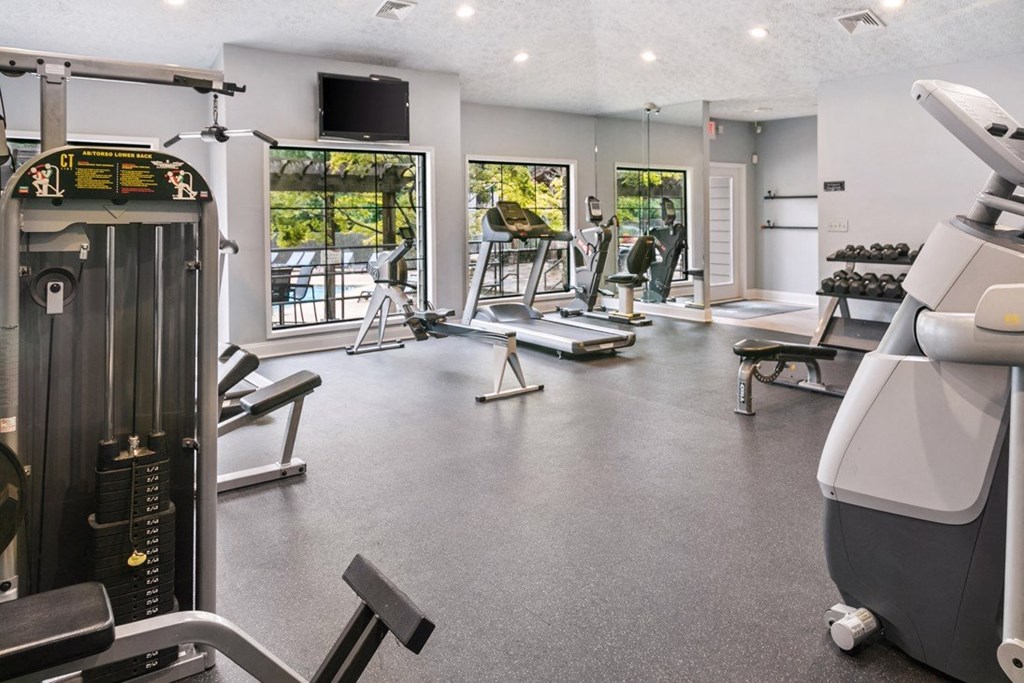 A gym with a variety of equipment including treadmills, weights, and exercise machines at Ridge Crossings Apartments, Hoover, AL