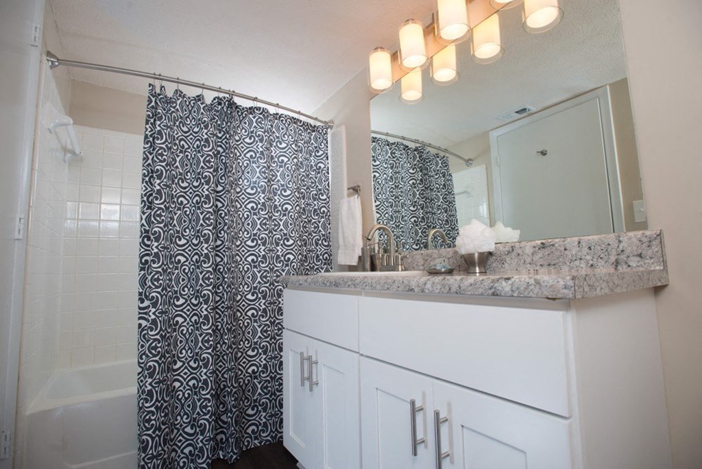A bathroom with a shower curtain and a counter at Ridge Crossings Apartments, Hoover