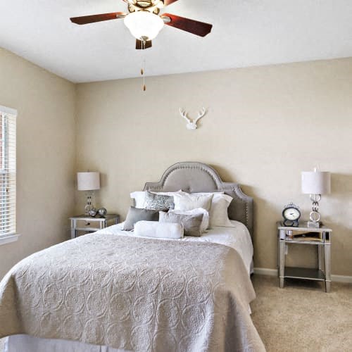 A bedroom with a large bed and a ceiling fan.