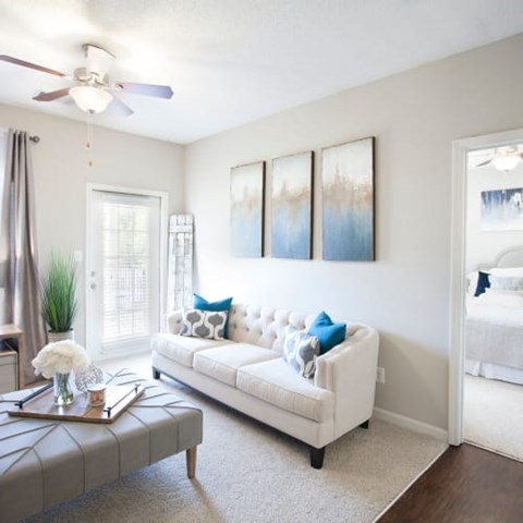 A living room with a white couch and a grey coffee table.