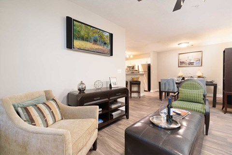 A living room with a couch, a chair, a coffee table, and a painting on the wall.