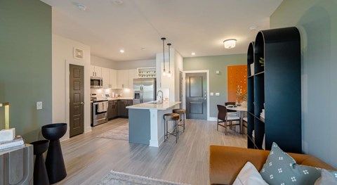A modern kitchen with a dining area and a living room.