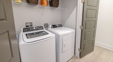A white washing machine and dryer in a laundry room.