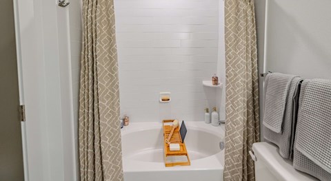 A bathroom with a white tub and a shower curtain.