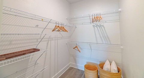 A white closet with a hanger and two baskets.